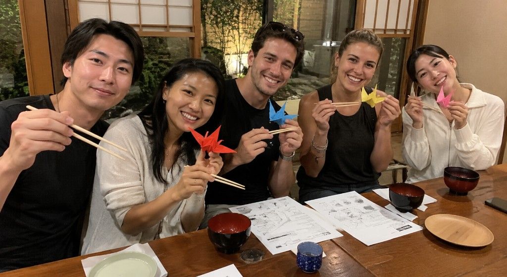 Team holding origami cranes with chopsticks during the Culture Clash challenge