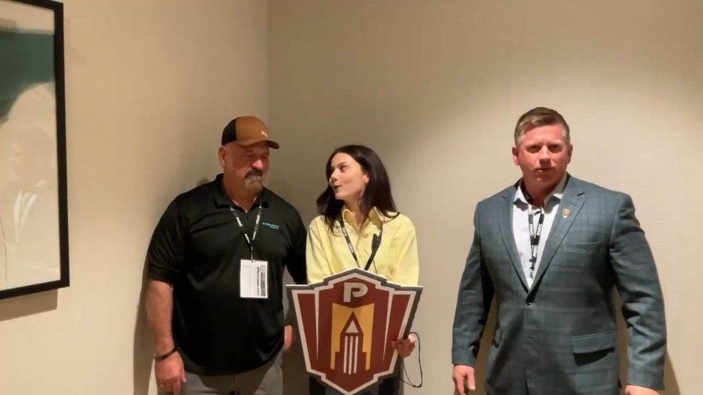 Team posing with a Paricon shield during the Pitch the Impossible challenge