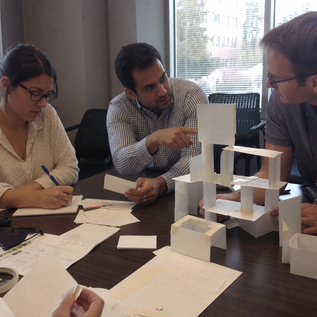Coworkers sharing ideas during an indoor tabletop team building challenge.