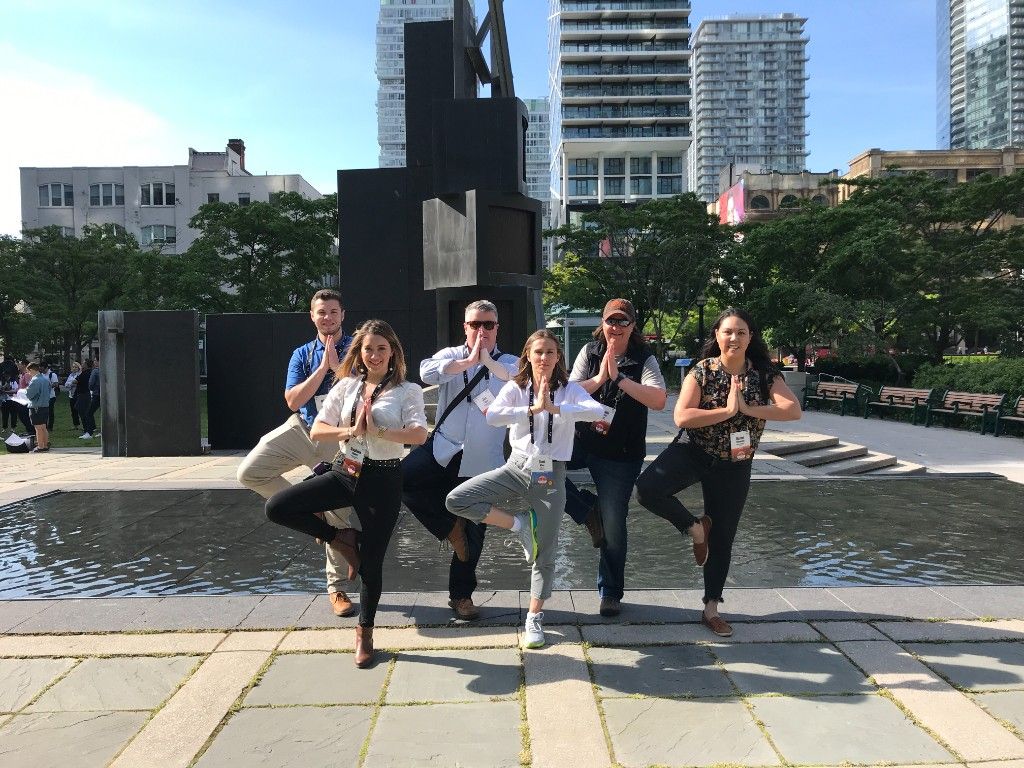 Team holding yoga poses in a city park